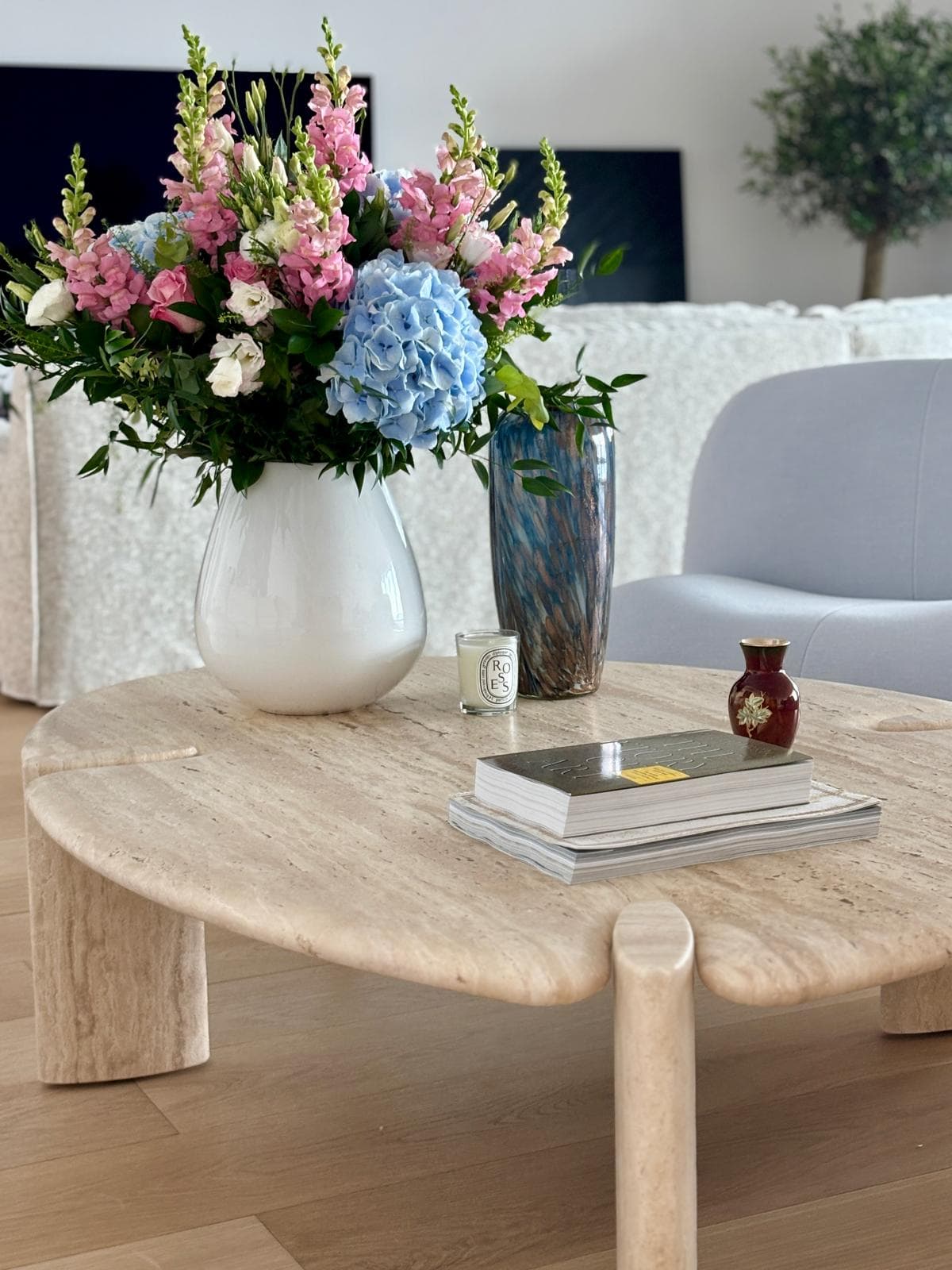 Residence Le Renzo living room styling with floral arrangement and travertine table